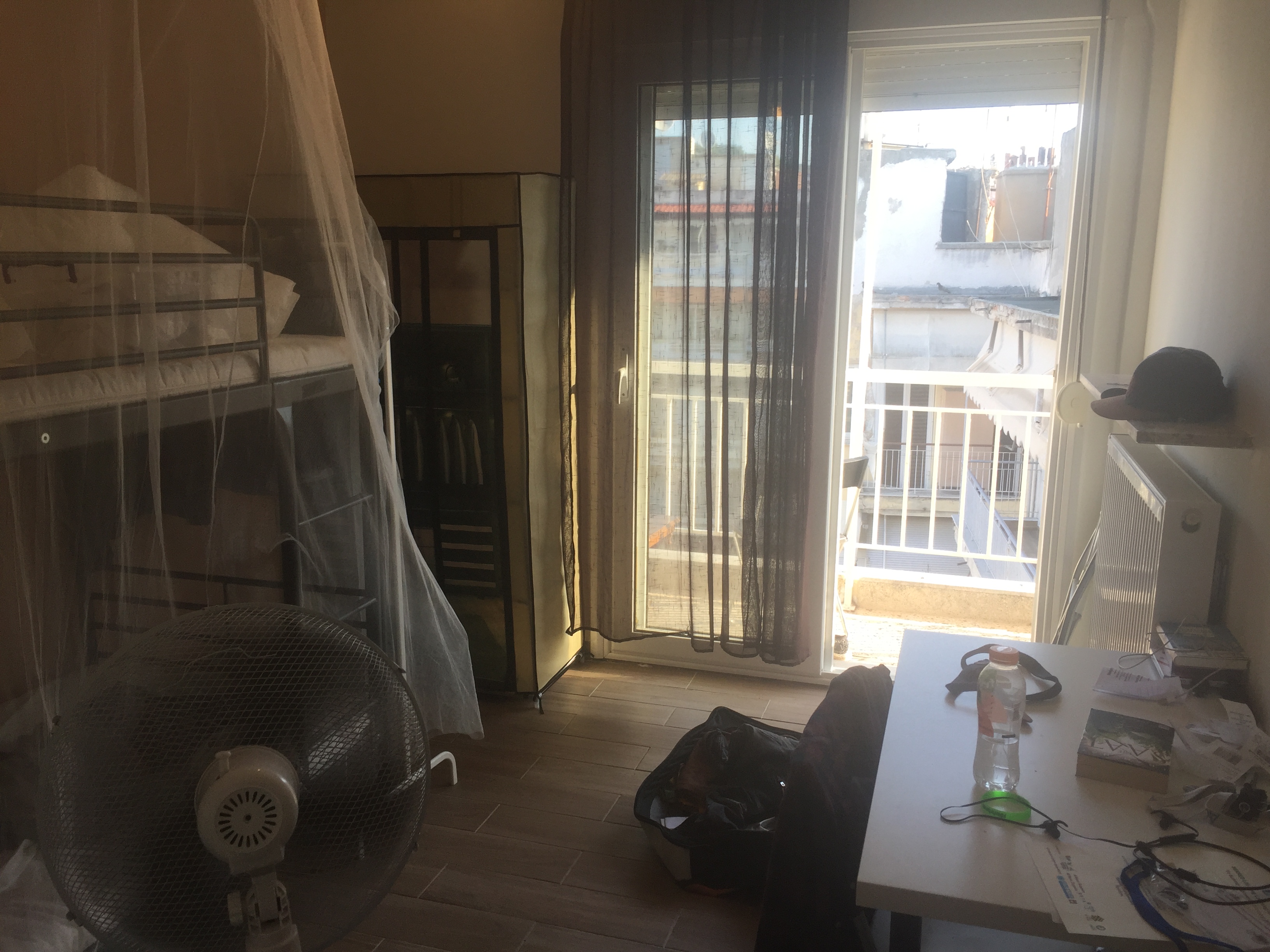 Mein Zimmer in Serres mit Zutritt zum Balkon und Hochbett sowie einem kleinen Schreibtisch.